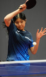 Person playing table tennis with a blue shirt and black paddle.