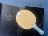 A table tennis paddle with a light wood-look blade and a blue handle, shown resting on top of its black presentation box.