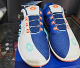 A pair of blue and white athletic shoes with orange accents and dial-up laces, resting on a blue shoebox.